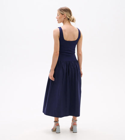 Back view of a navy sleeveless midi dress with fitted bodice and gathered skirt