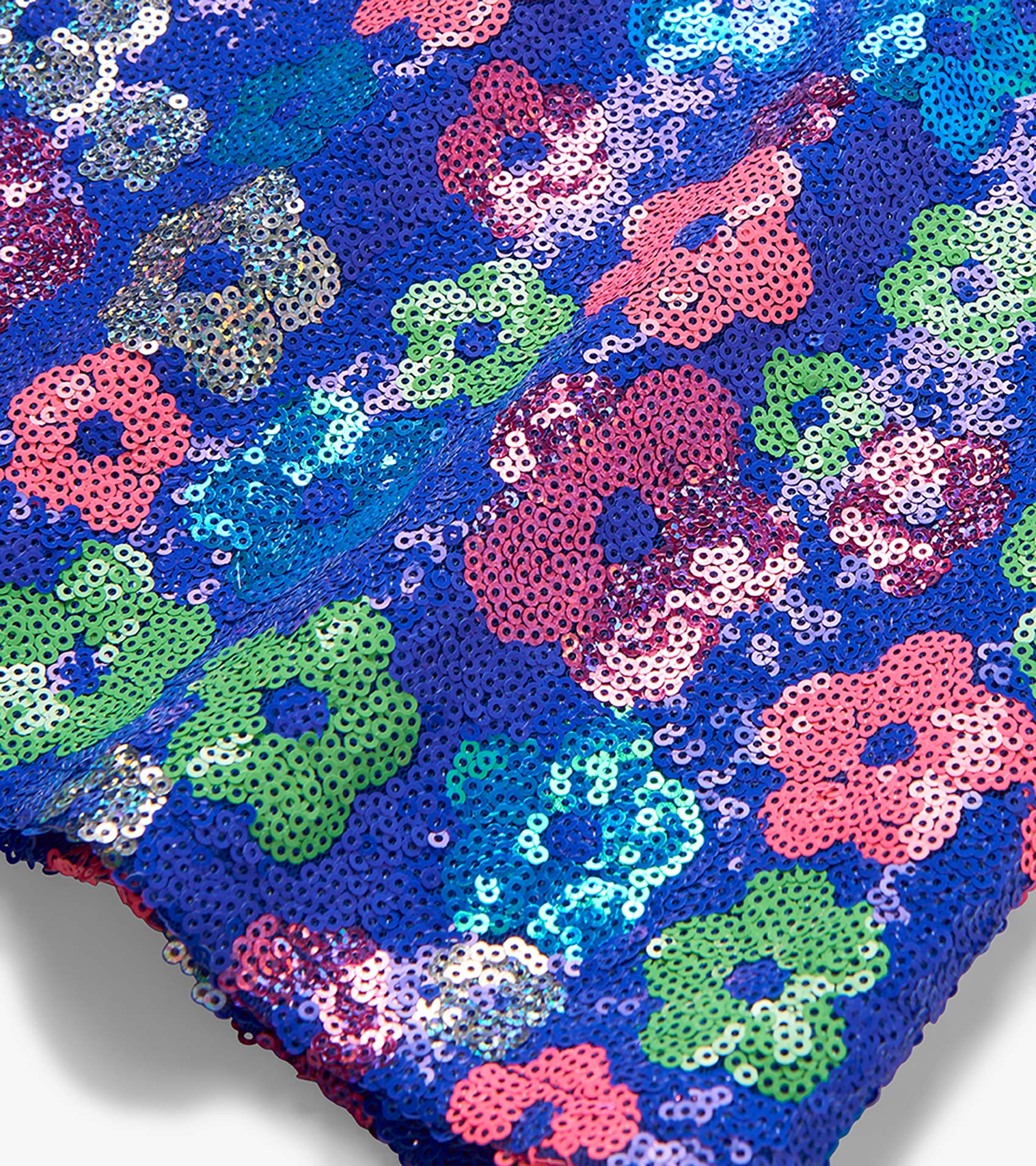 Close-up of a blue sequin top with colorful floral pattern in pink, green, and turquoise