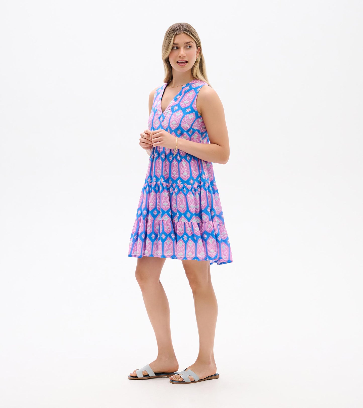 Sleeveless blue dress with pink floral print, shown from the side with V-neck and tiered skirt