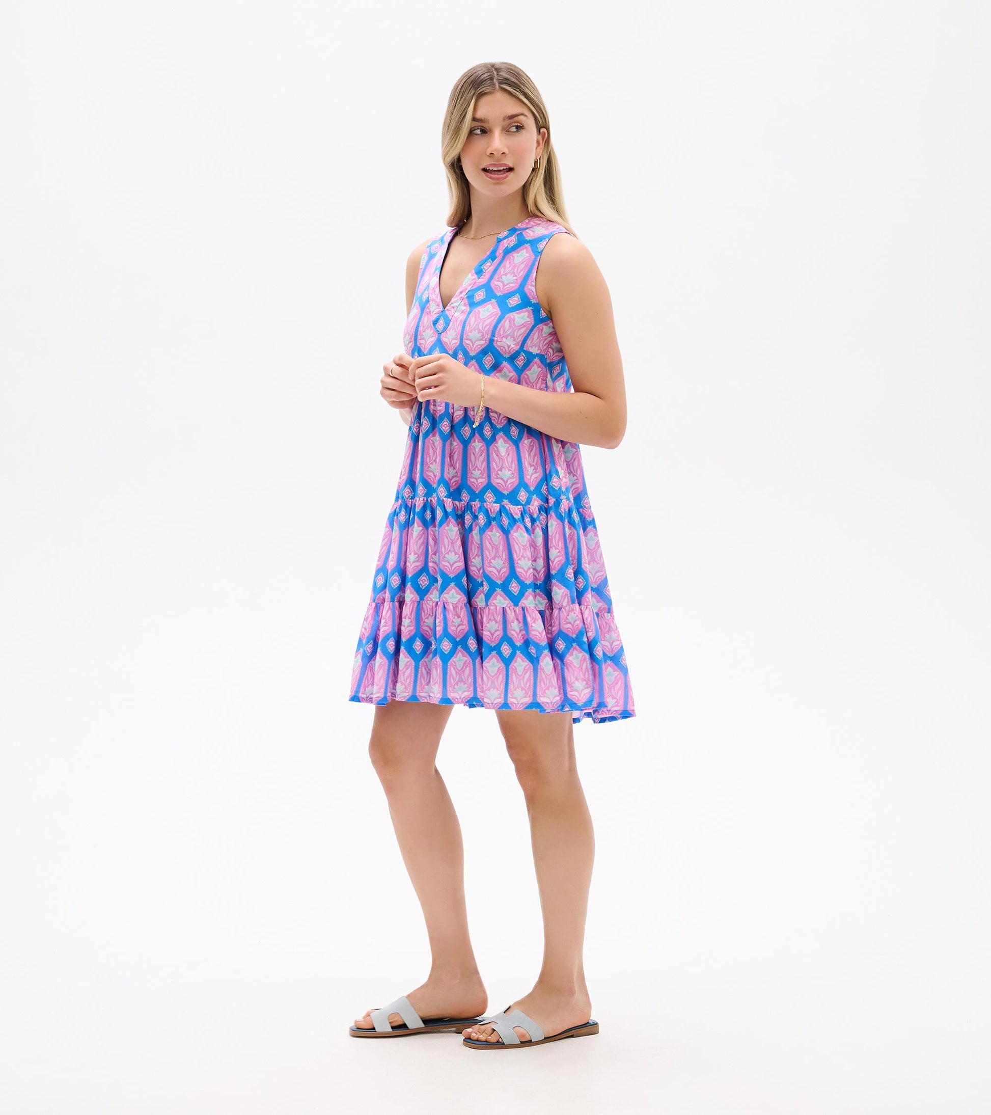 Sleeveless blue dress with pink floral print, shown from the side with V-neck and tiered skirt