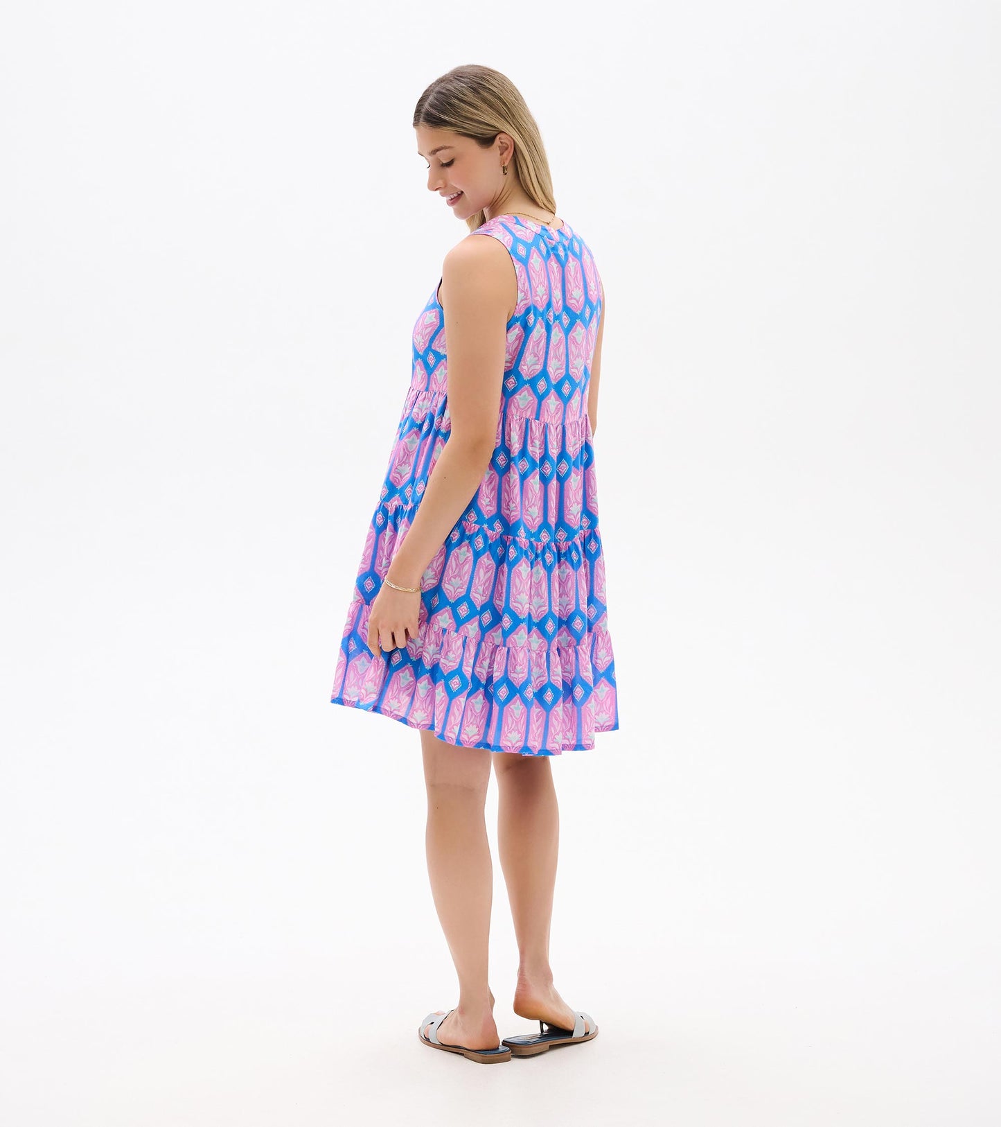 Sleeveless blue dress with pink floral print, shown from the back with tiered skirt