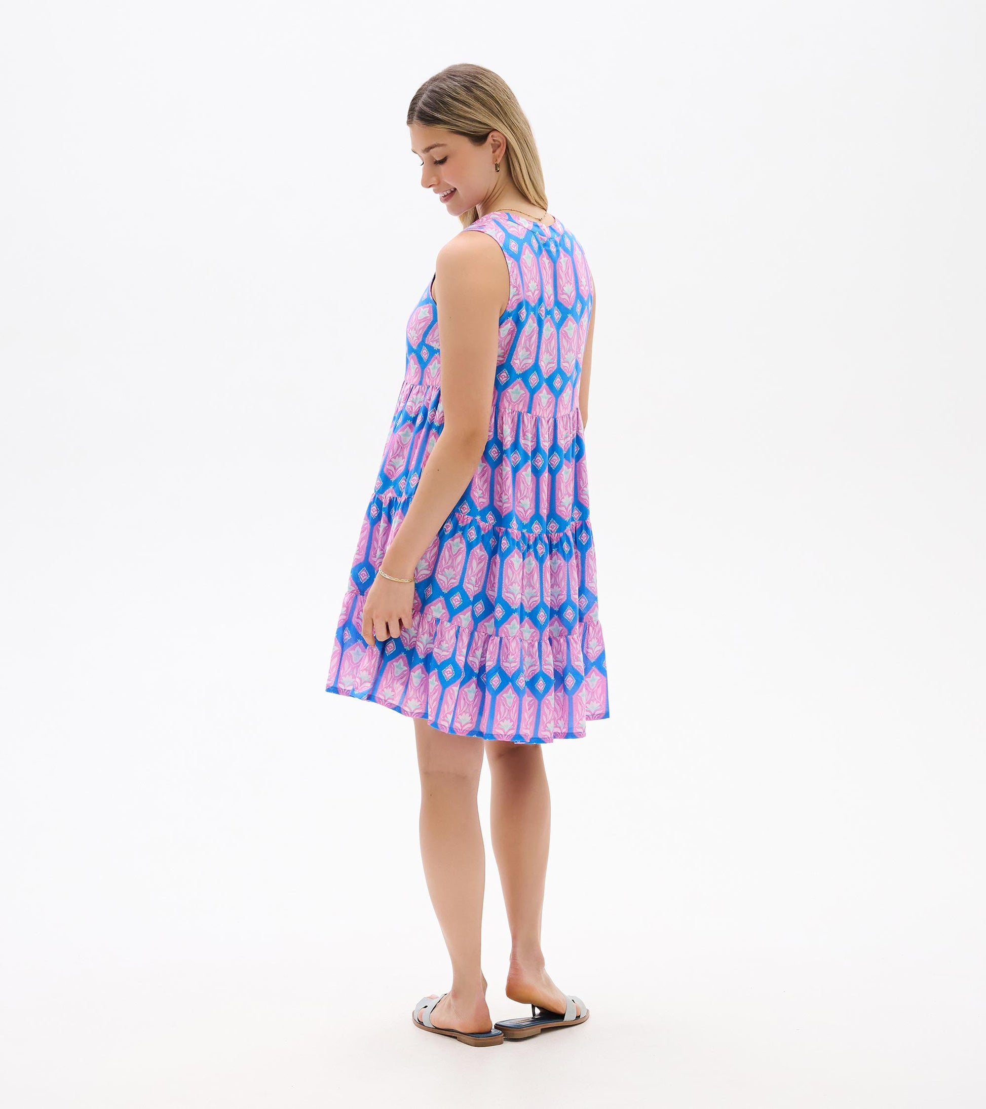 Sleeveless blue dress with pink floral print, shown from the back with tiered skirt