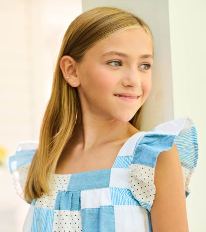 Close-up of blue and white patchwork dress with flutter sleeves and square neckline on model