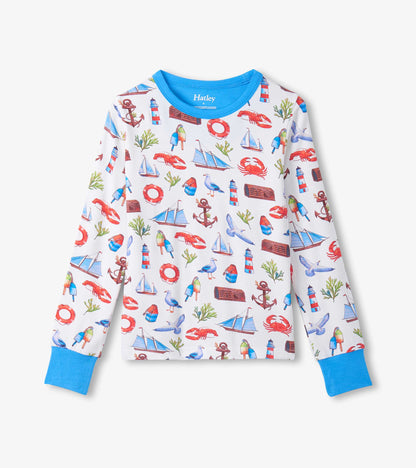 Long-sleeve white pajama top with blue trim and colorful seascape print of boats, lighthouses, anchors, and crabs