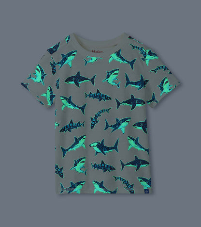 Cream boys shark print tee shown glowing in the dark with bright blue shark outlines
