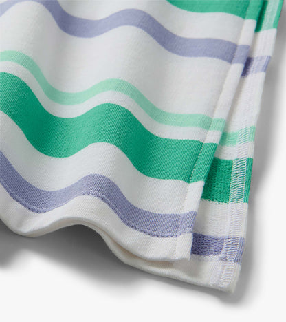 Close-up of white midi dress fabric with wavy green and lavender stripes and stitched hem detail