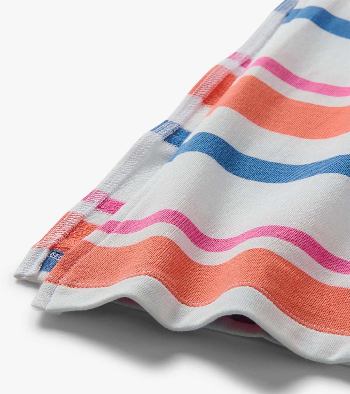 Close-up of white midi dress fabric with colorful horizontal stripes and pleated sleeve detail