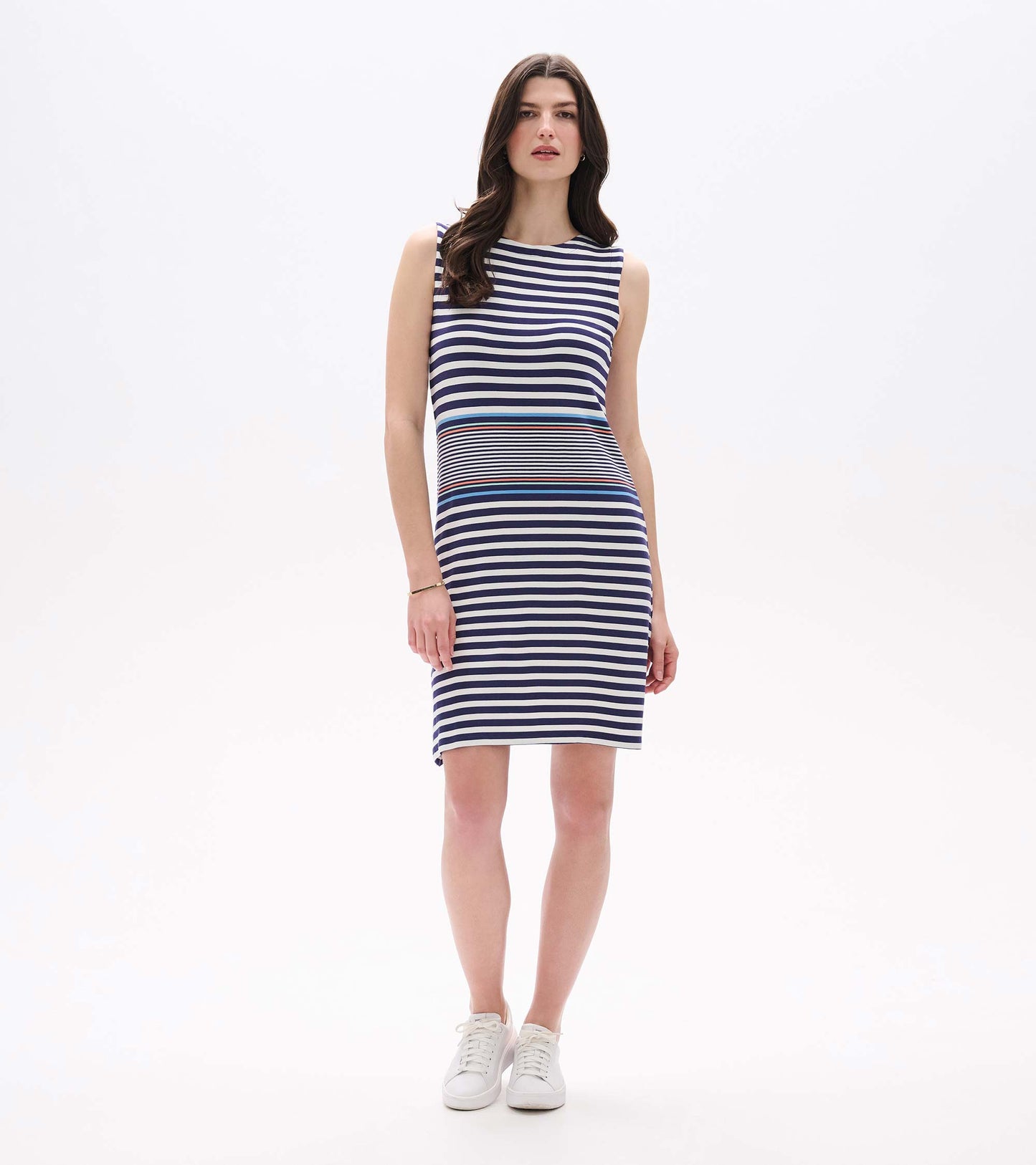 Angled front view of sleeveless knee-length striped dress with white sneakers