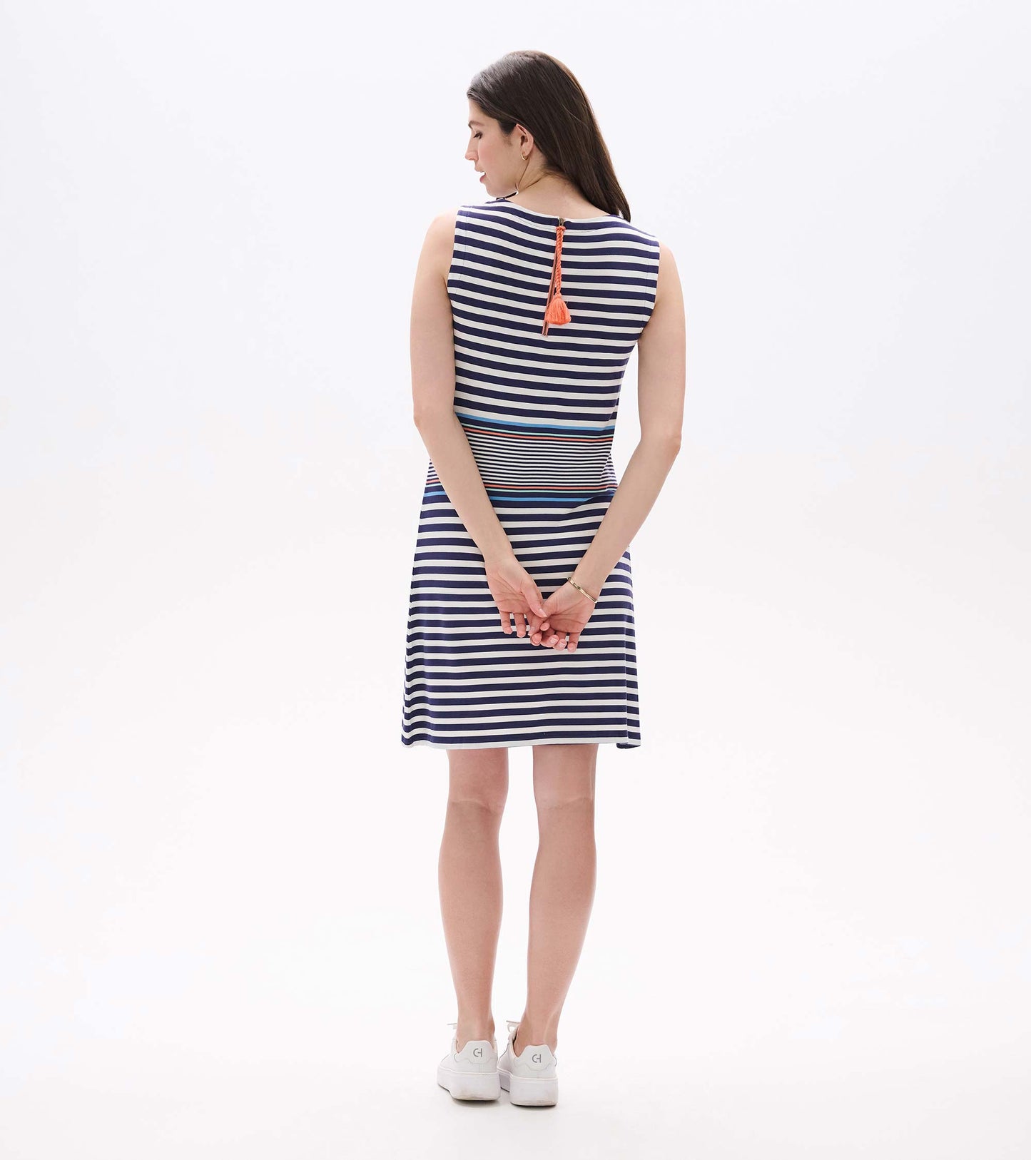 Back view of sleeveless striped dress with exposed back zipper and coral tassel pull