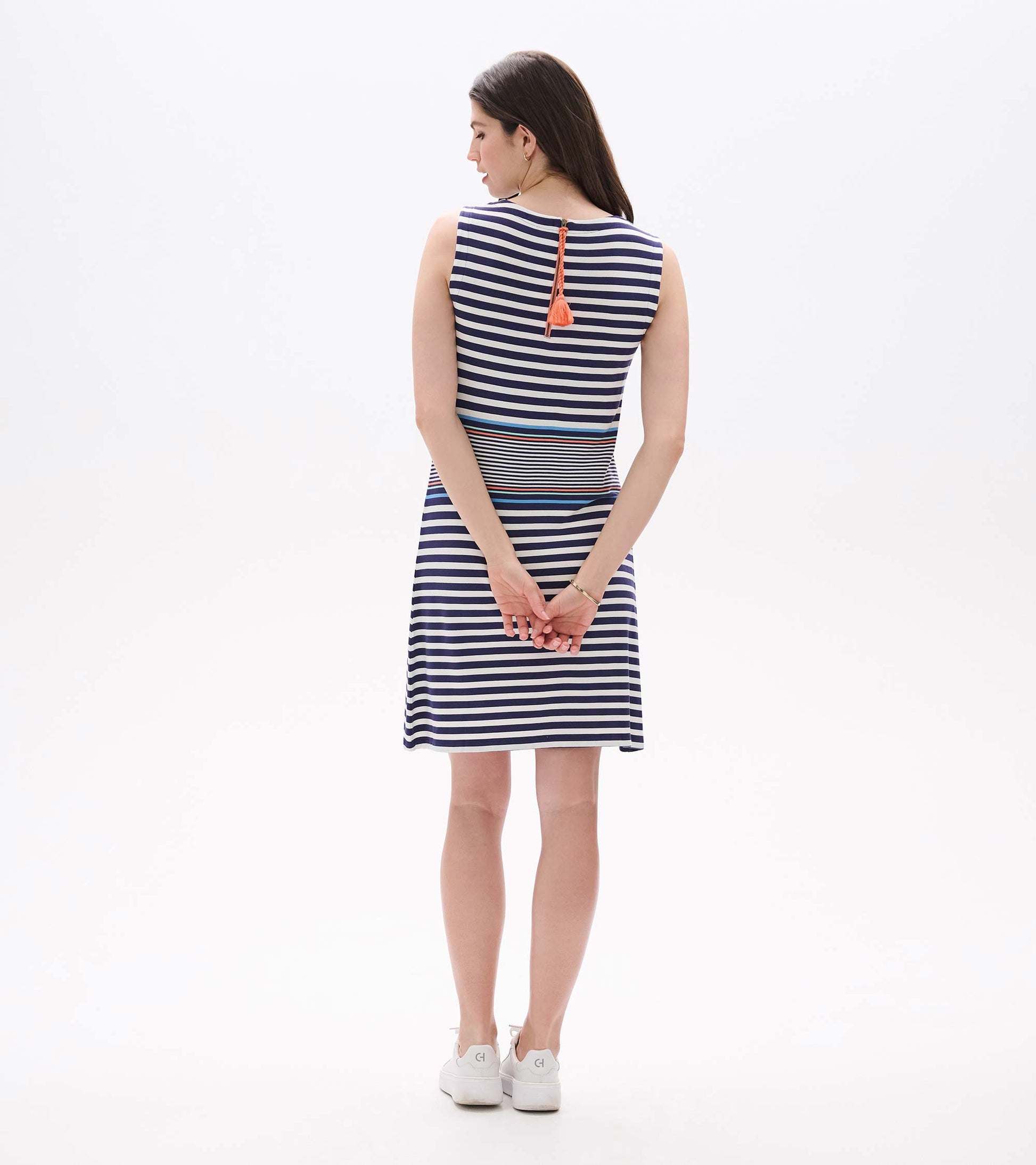 Back view of sleeveless striped dress with exposed back zipper and coral tassel pull