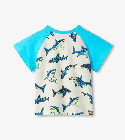 Short-sleeve raglan T-shirt with bright blue sleeves and cream body covered in blue shark print, front view