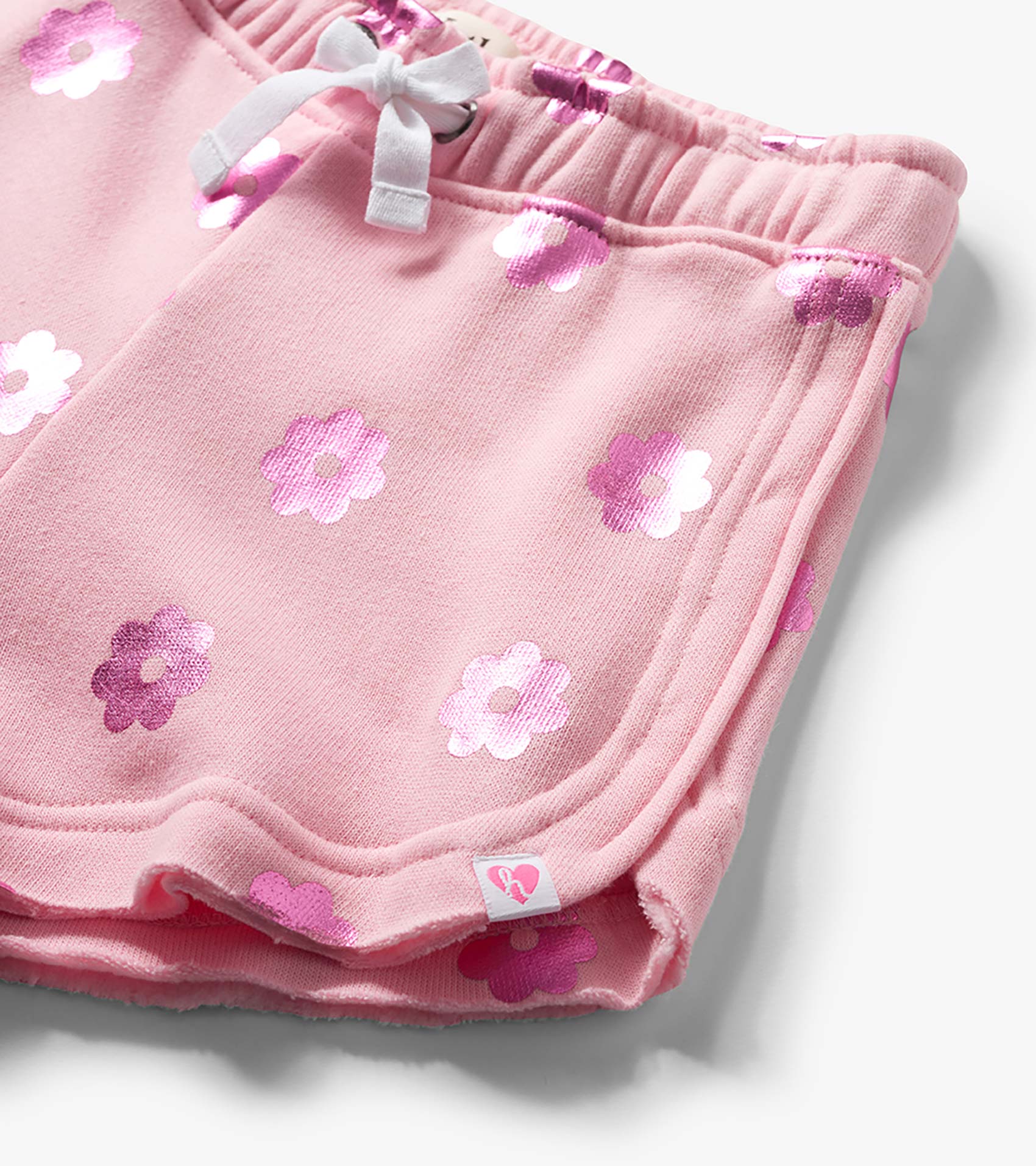 Pink pull-on shorts with white drawstring and pink floral print, close-up front view