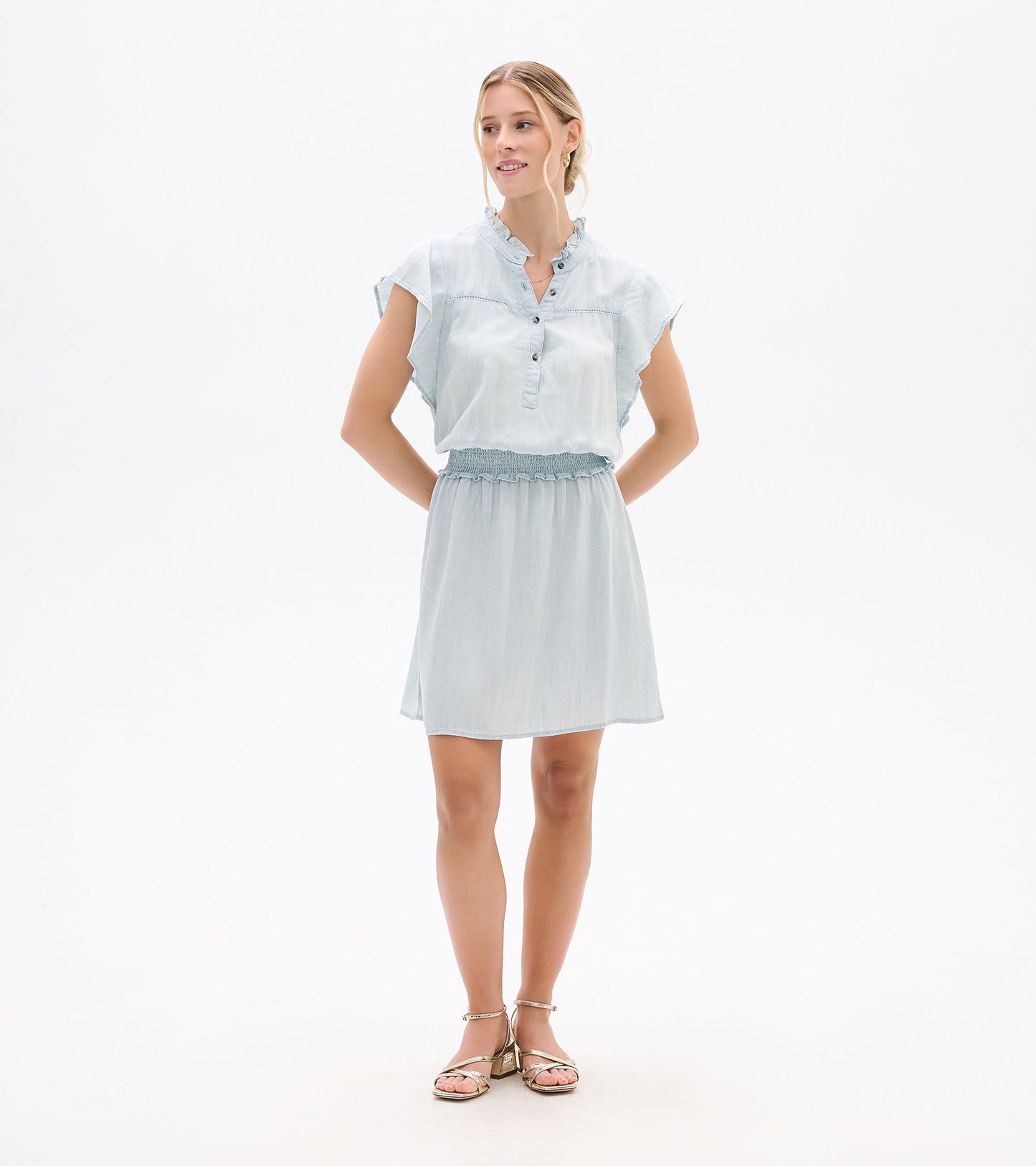 Front view of a light blue short-sleeve dress with ruffled collar, button placket, and smocked waist