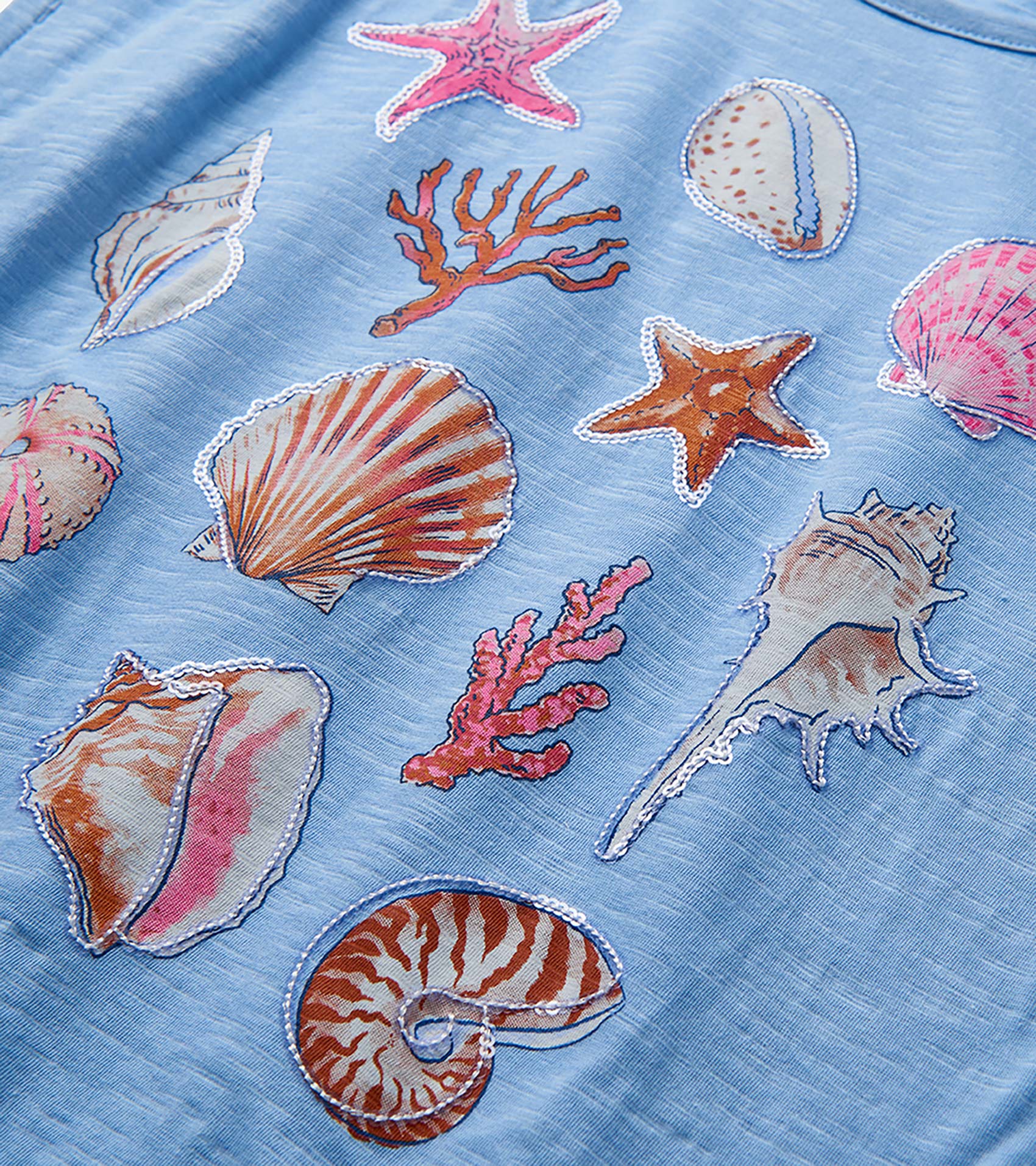 Light blue girls top with colorful seashell and starfish print close-up