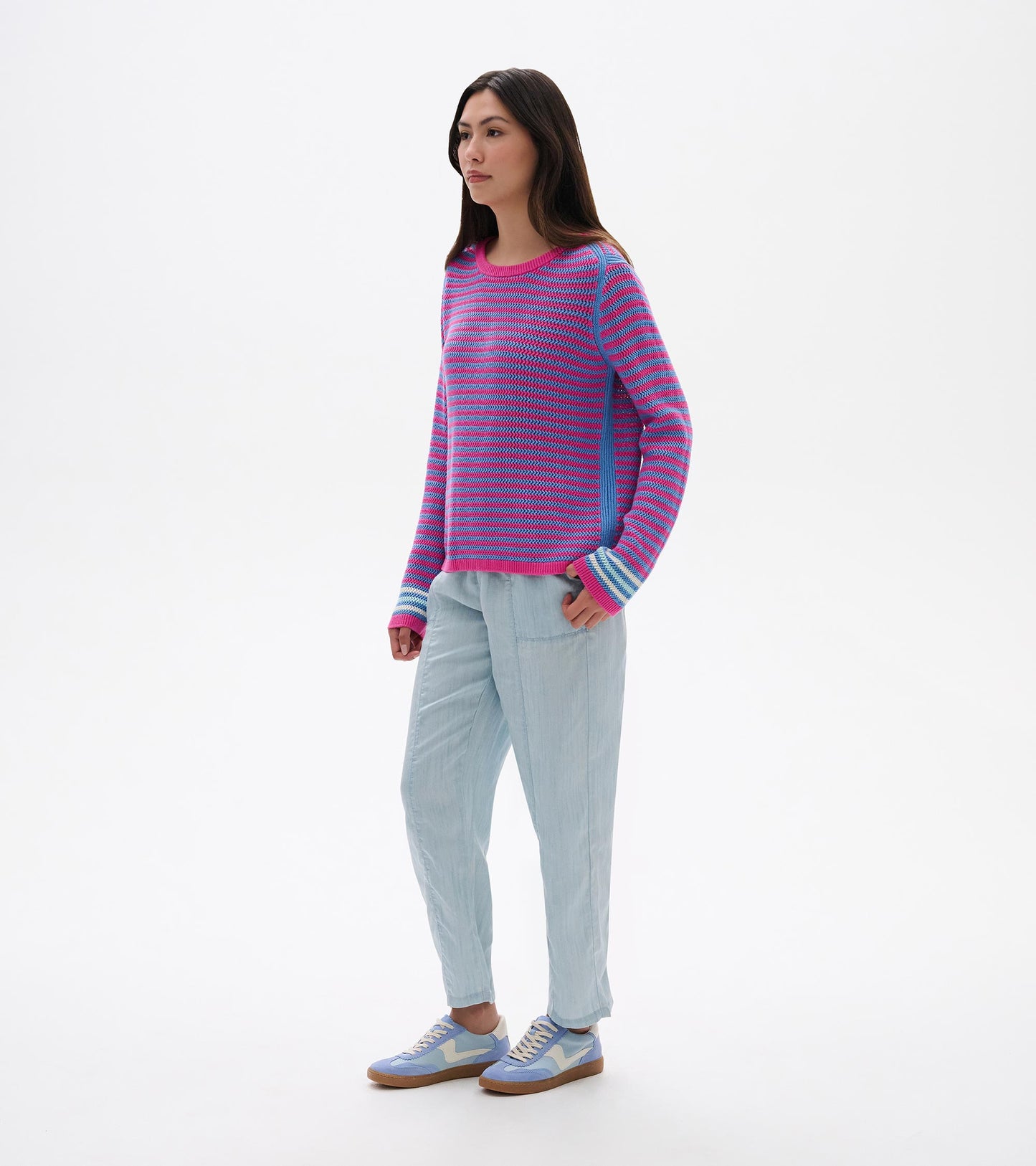 Front view of a pink and blue striped knit sweater with long sleeves and ribbed trim on a model