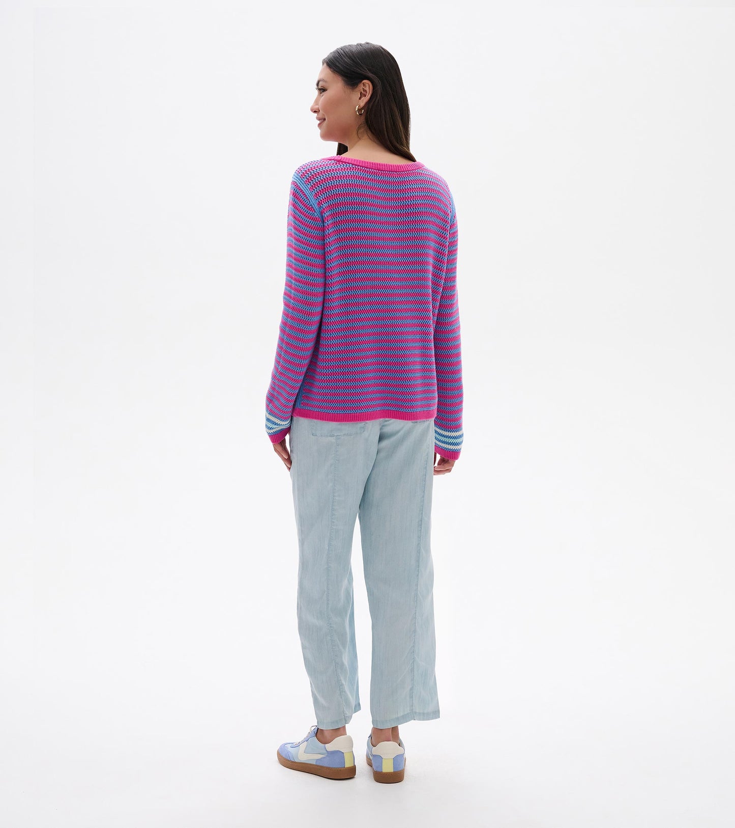 Back view of a pink and blue striped pointelle knit sweater with long sleeves and ribbed trim