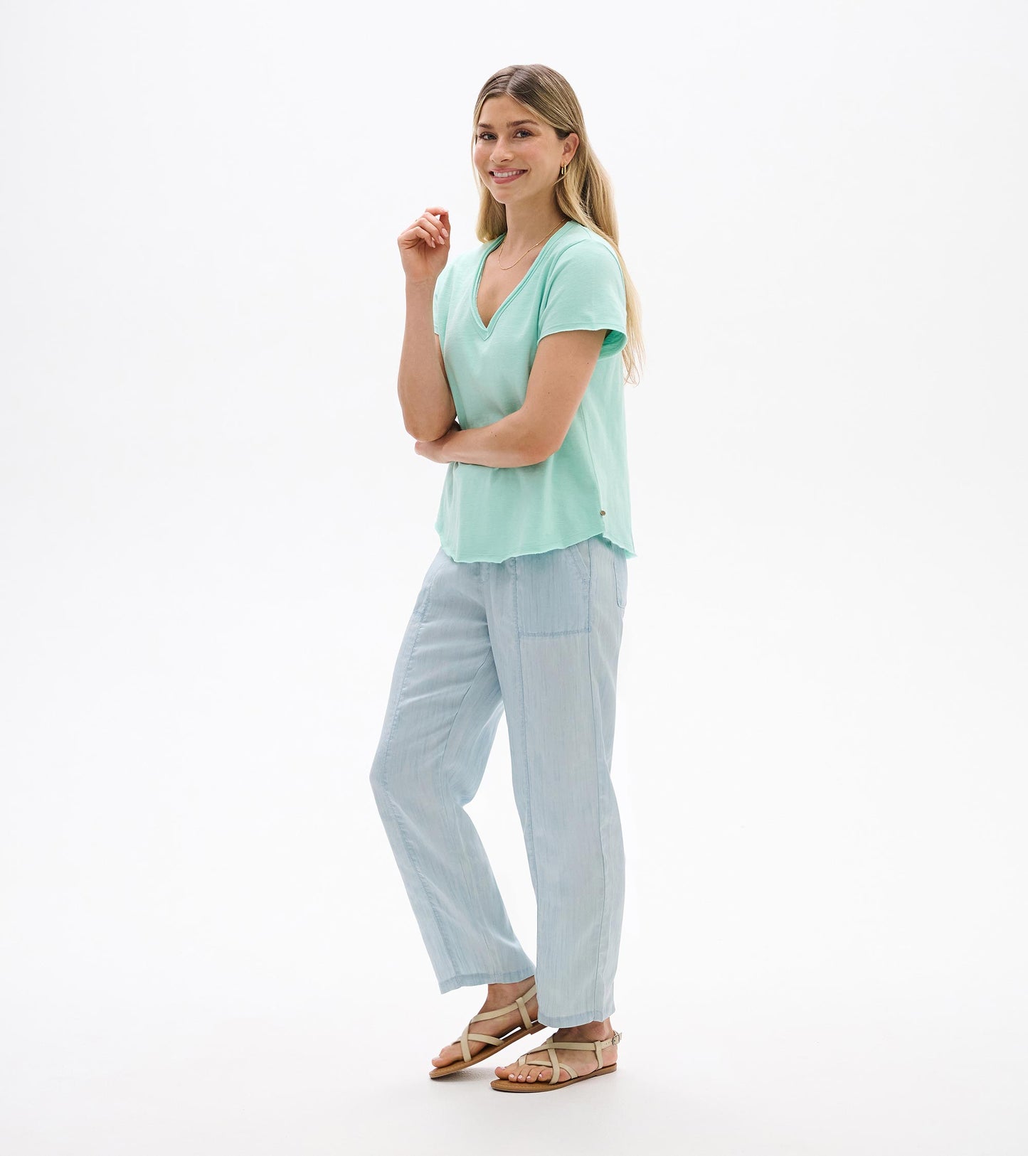 Woman wearing a sea glass green V-neck short-sleeve tee with a relaxed fit, front view.