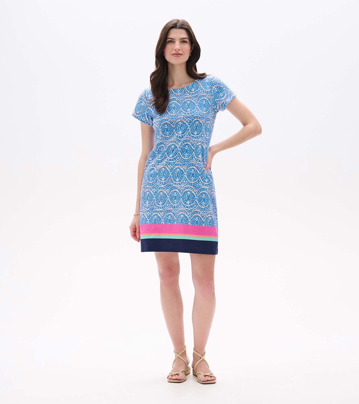 Front view of blue and white ikat tee dress with short sleeves and colorful striped border hem