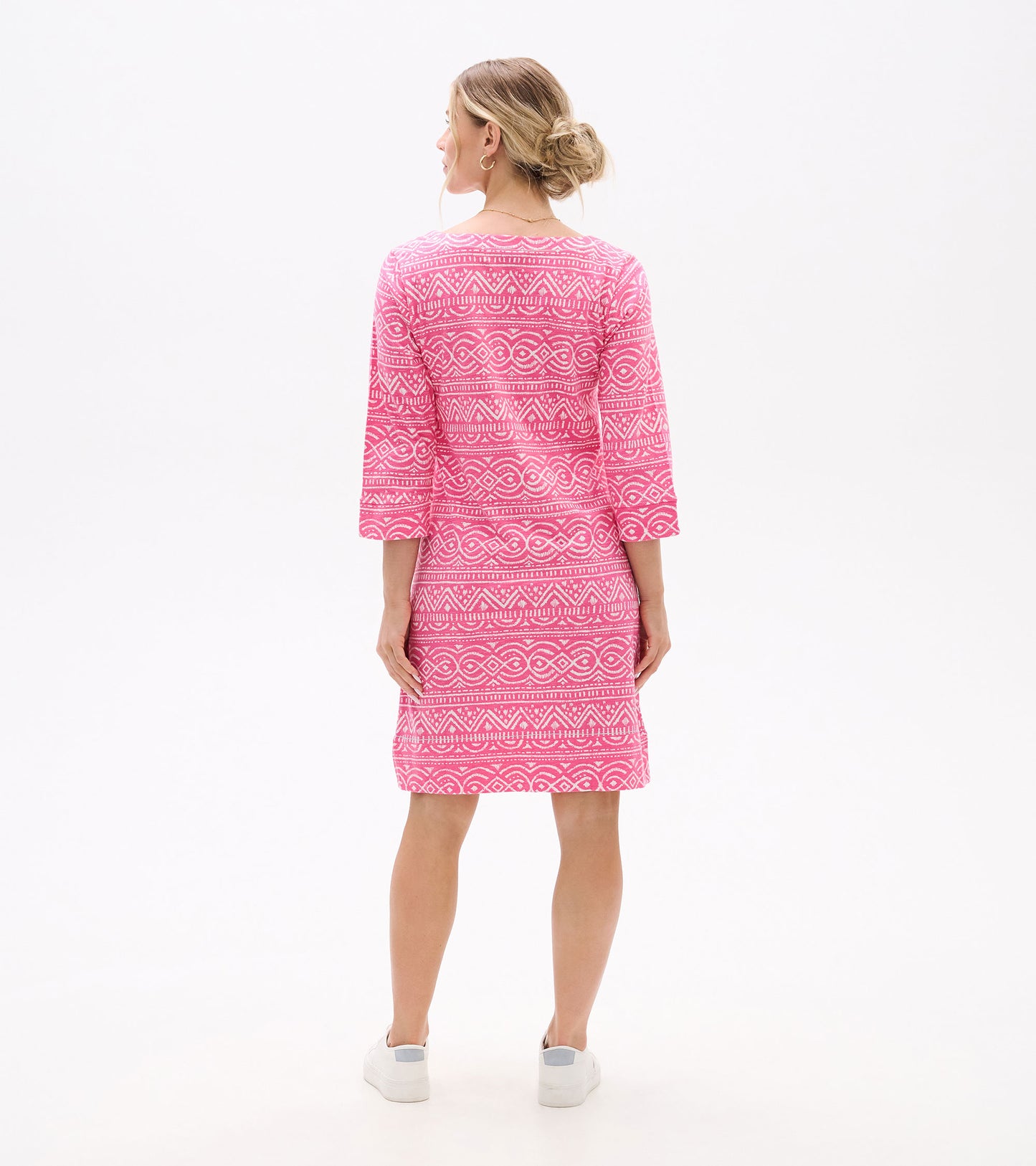 Back view of pink knee-length dress with white geometric line pattern and three-quarter sleeves