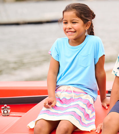 Girls pastel striped crochet skirt with scalloped hem and drawstring waist, worn by a child outdoors