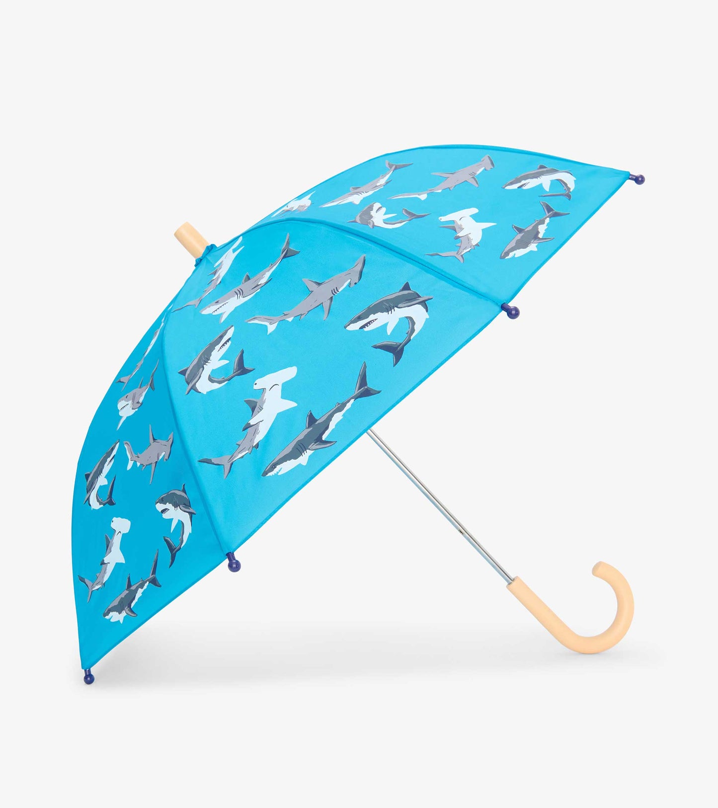 Blue kids umbrella with shark print, tan curved handle, and silver shaft on white background