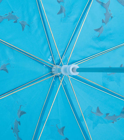 Blue umbrella canopy with shark pattern and silver spokes, close-up view