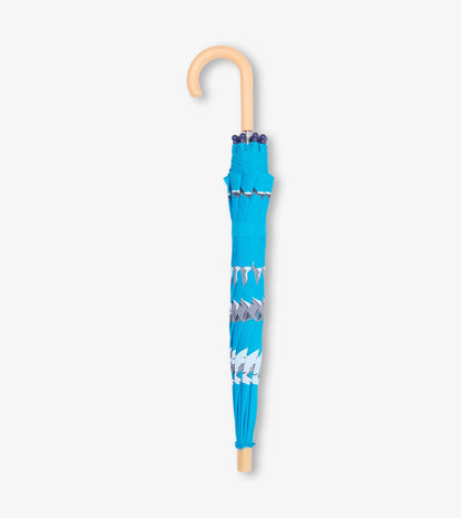Folded blue kids umbrella with shark pattern and beige curved handle
