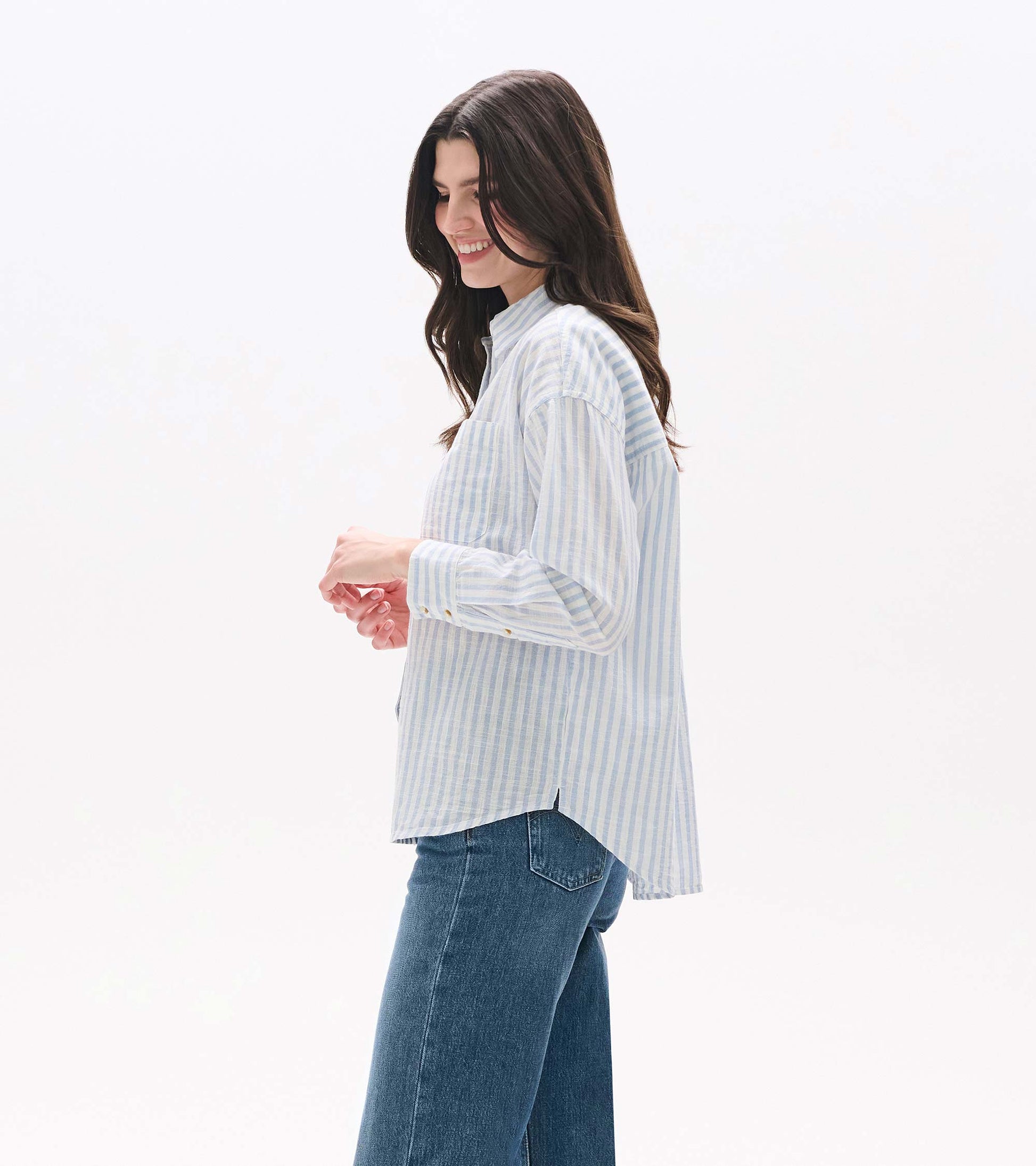 Side view of blue and white striped button-down shirt with curved hem and side vent