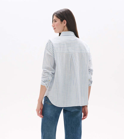 Back view of relaxed button-down shirt in pale blue and white stripes with curved hem and back pleat
