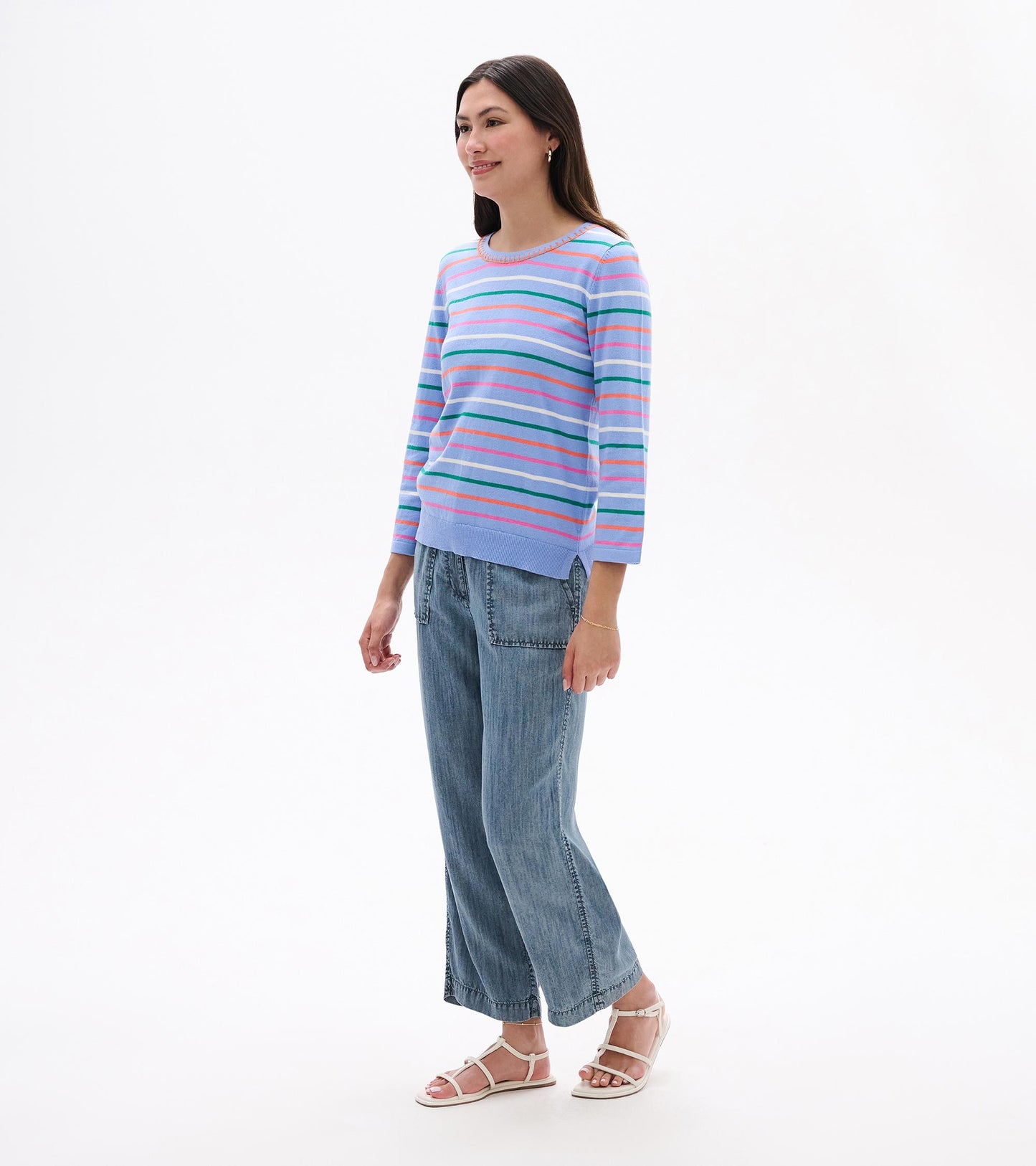 Woman wearing a light blue knit top with multicolor horizontal stripes and 3/4 sleeves, front view