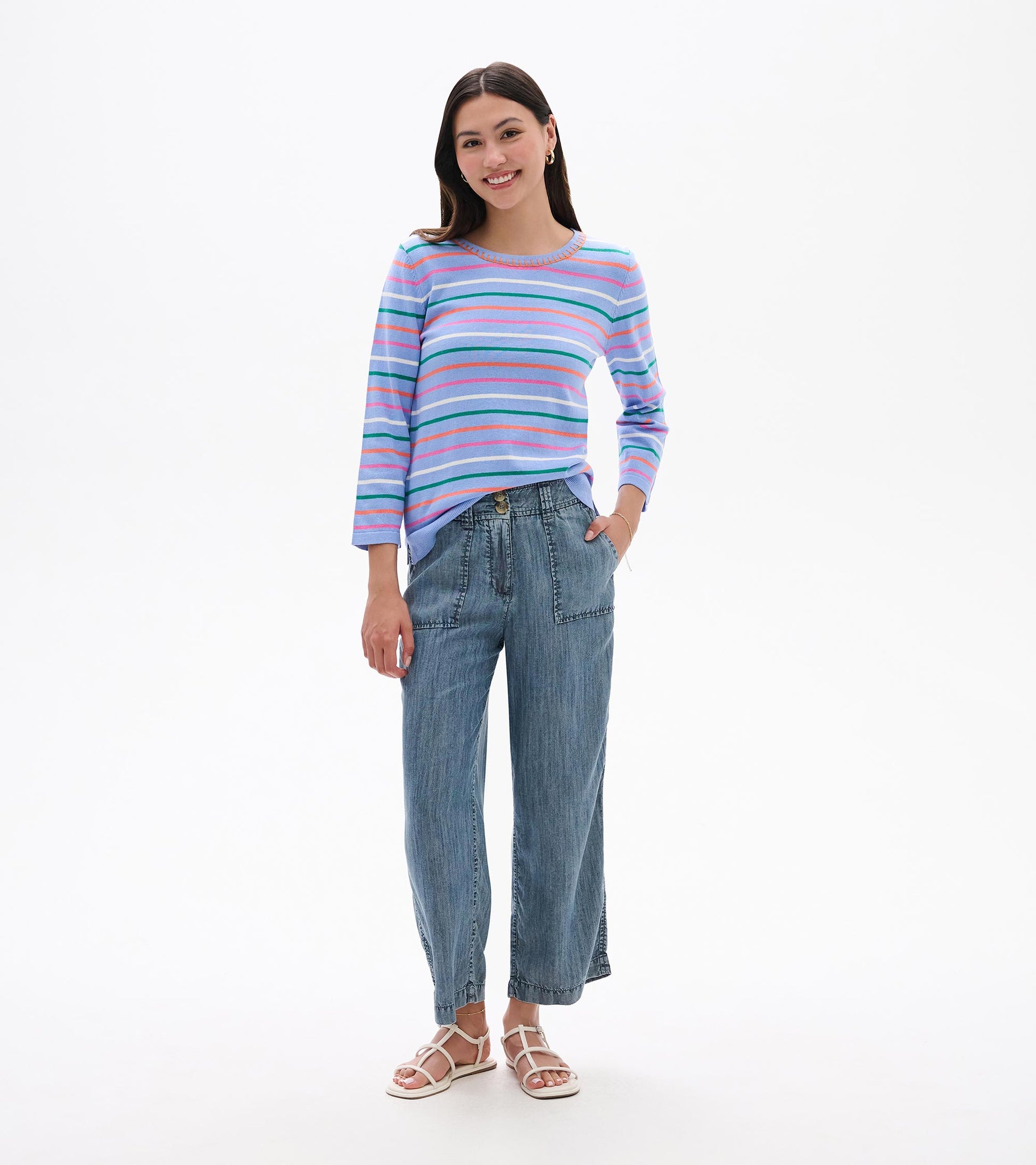 Woman wearing a light blue knit top with multicolor horizontal stripes and 3/4 sleeves, front view
