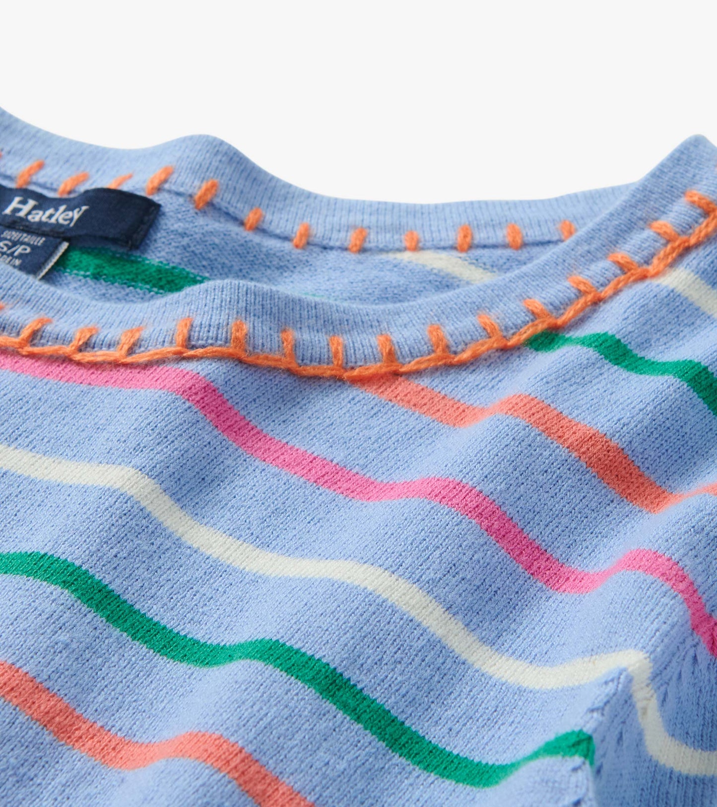 Close-up of a light blue knit top with multicolor wavy stripes and orange stitching at the neckline.