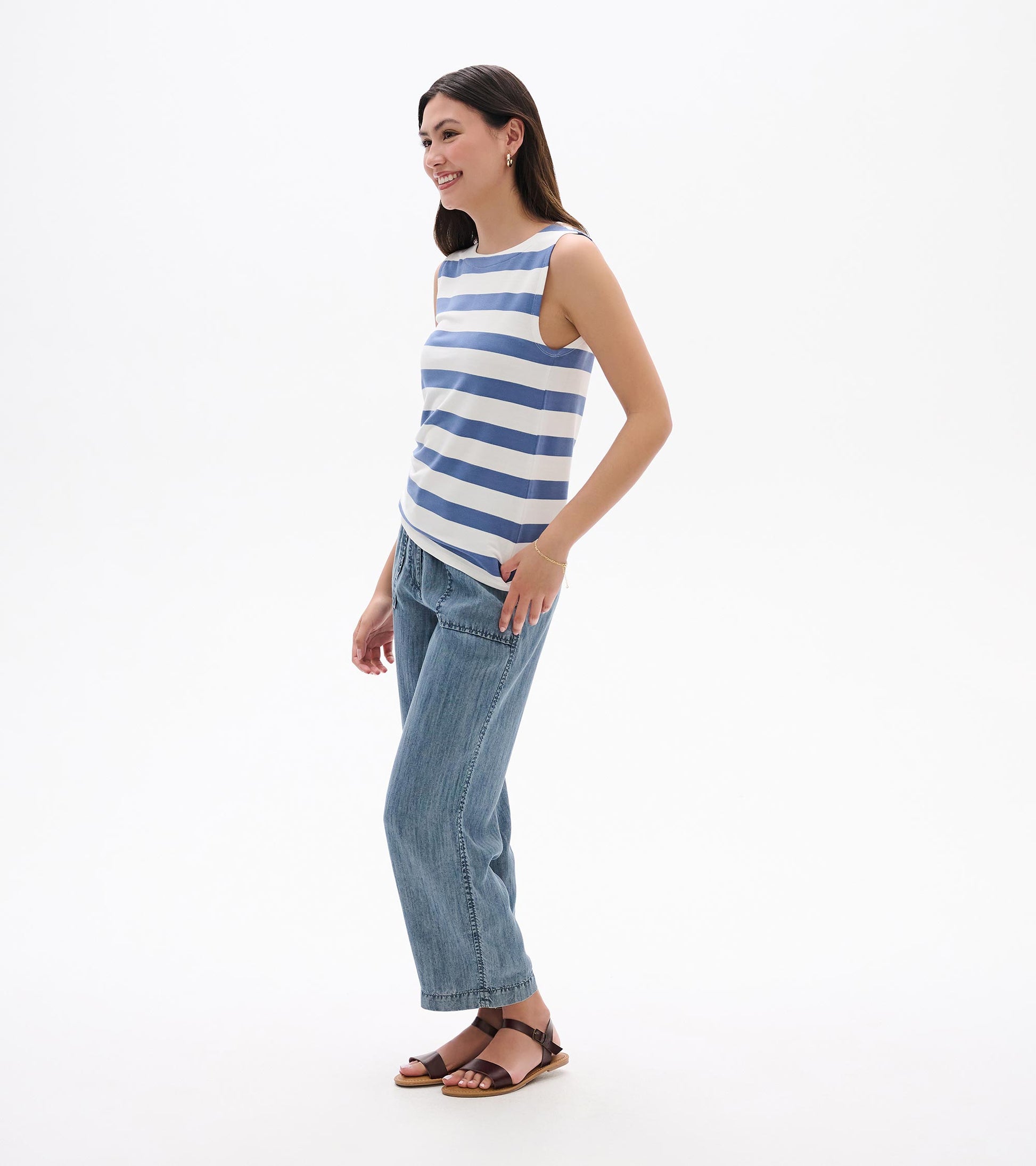 Sleeveless blue-and-white striped tank top, side view, worn with jeans and sandals
