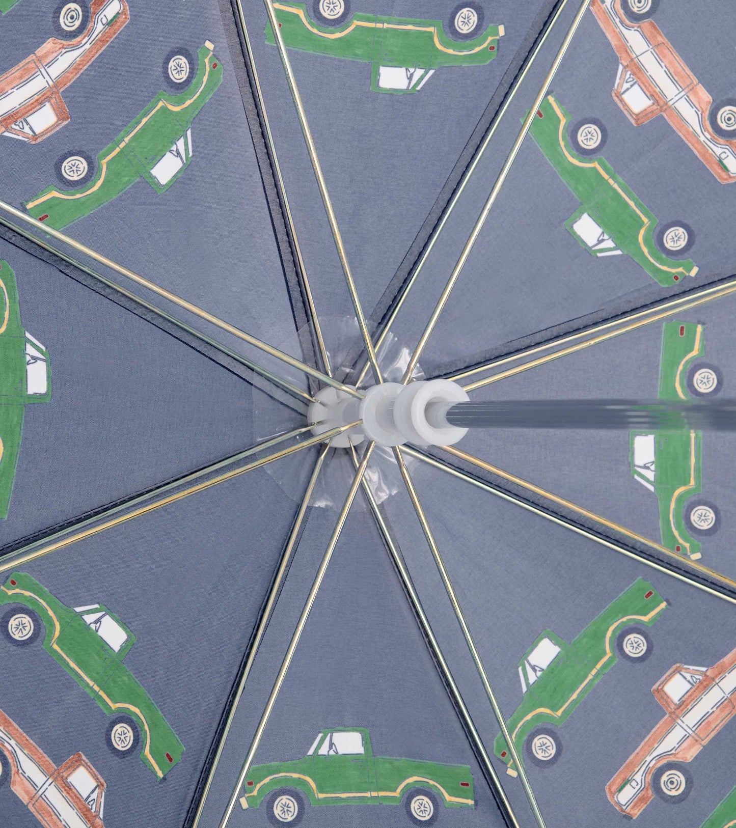 Interior view of a gray kids umbrella with green and orange truck print and metal spokes