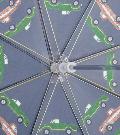 Interior view of a gray kids umbrella with green and orange truck print and metal spokes