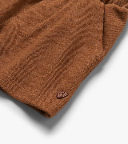Close-up of toasted coconut brown pull-on shorts with textured fabric and small logo patch at hem