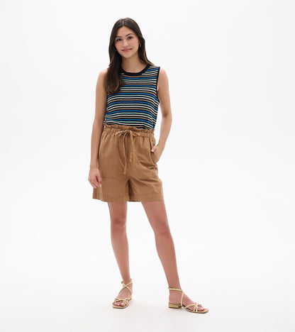 Woman wearing tan drawstring shorts with front pockets, shown front view.