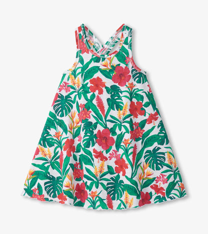 Girls white trapeze dress with green tropical leaves and red floral print, sleeveless with scoop neckline
