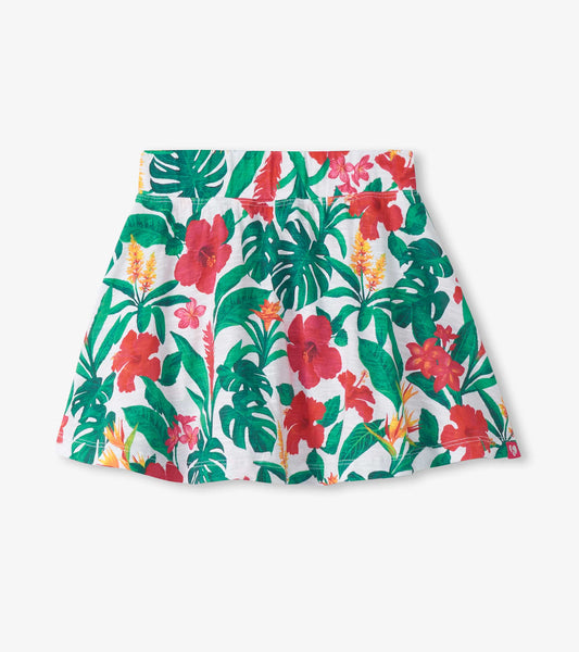 Girls tropical floral skort with white background, green leaves, and red pink flower print