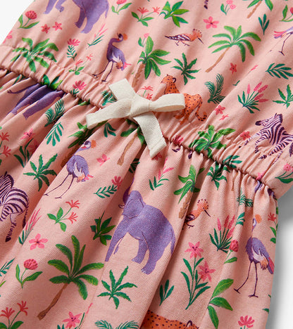 Pink short sleeve dress with safari animal and palm print, gathered waist, and cream tie detail