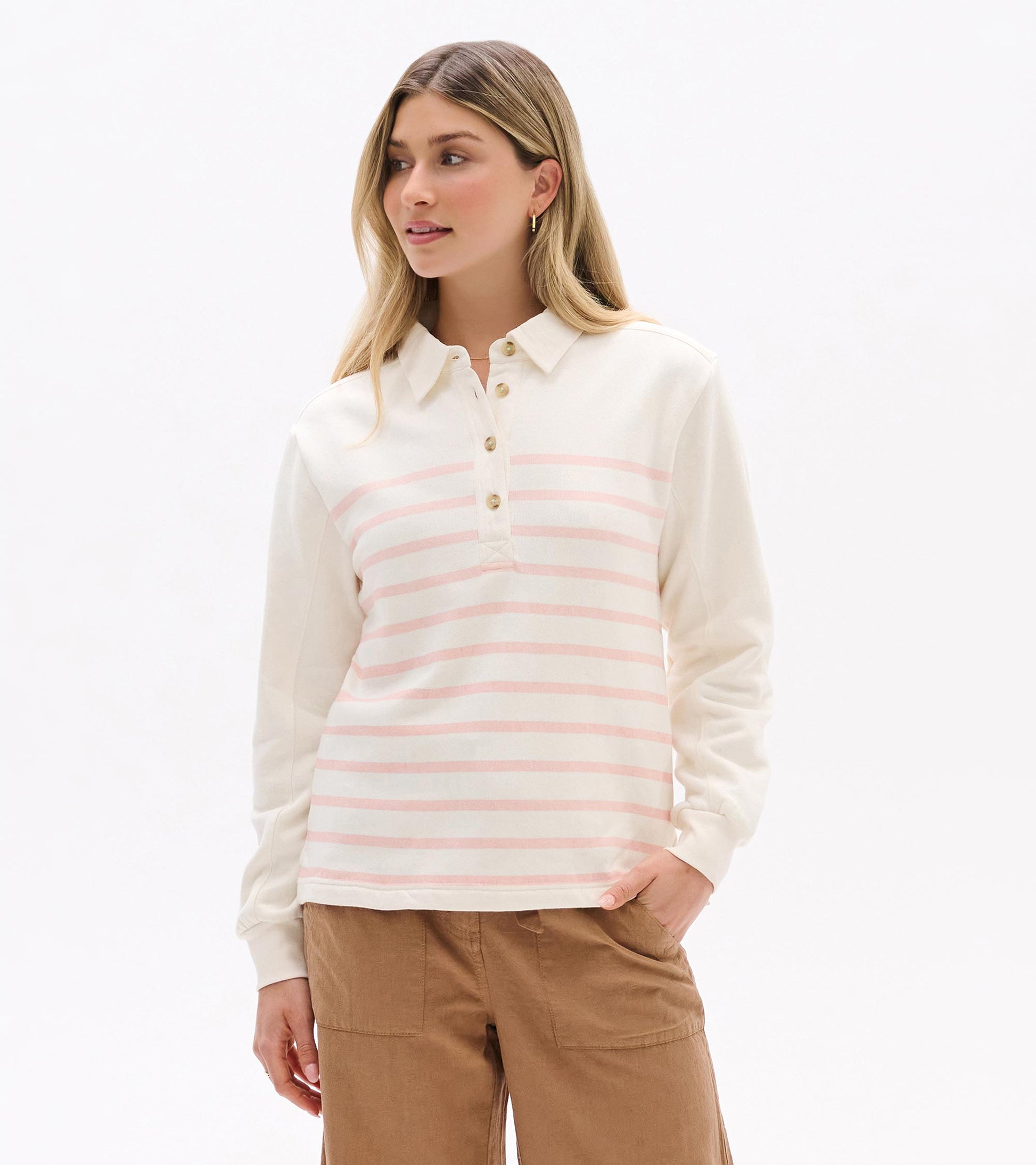 Cream long-sleeve polo top with pink stripes, button placket, and collar, worn by model front view