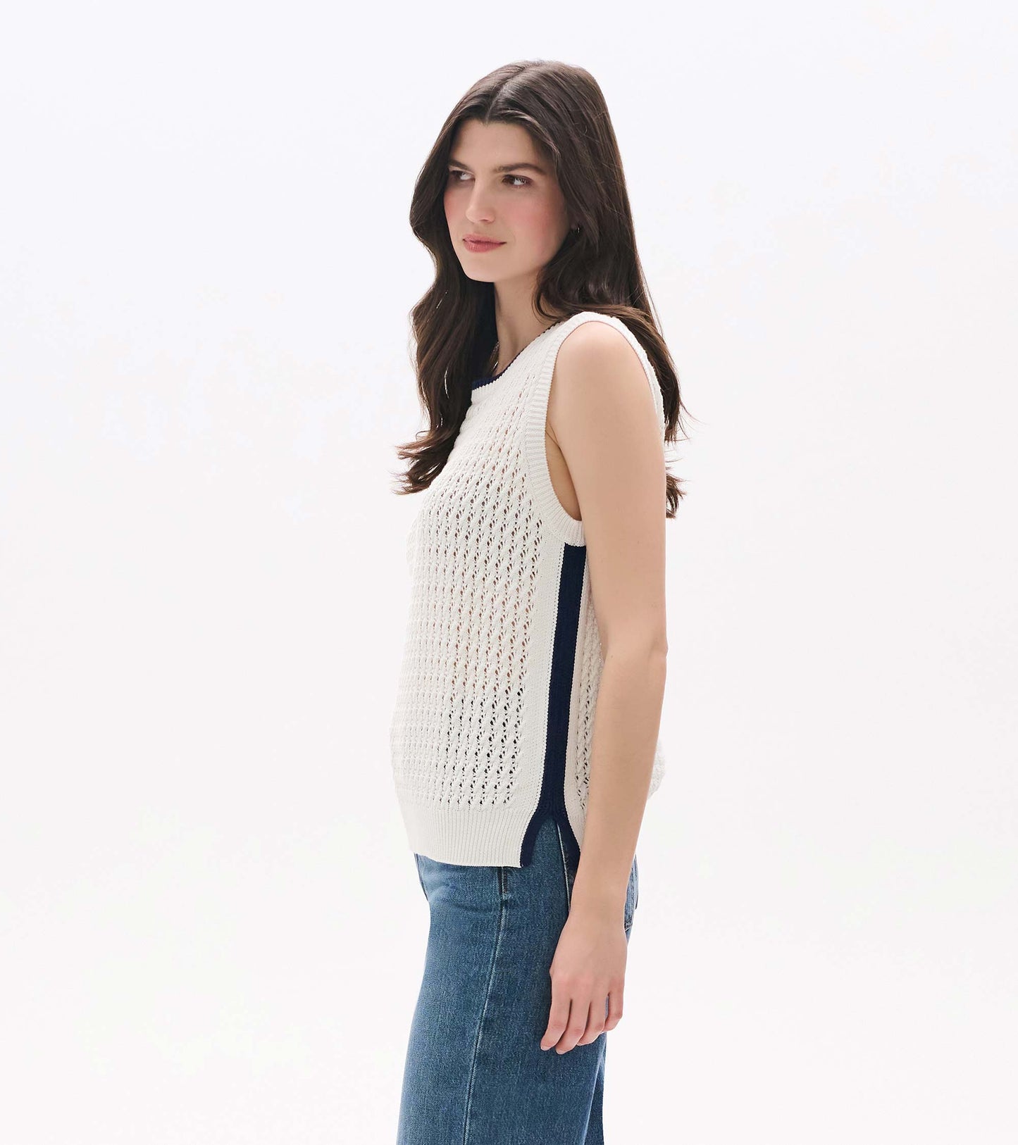 White sleeveless knit tank with open mesh texture and side slits, shown on a model in side view.