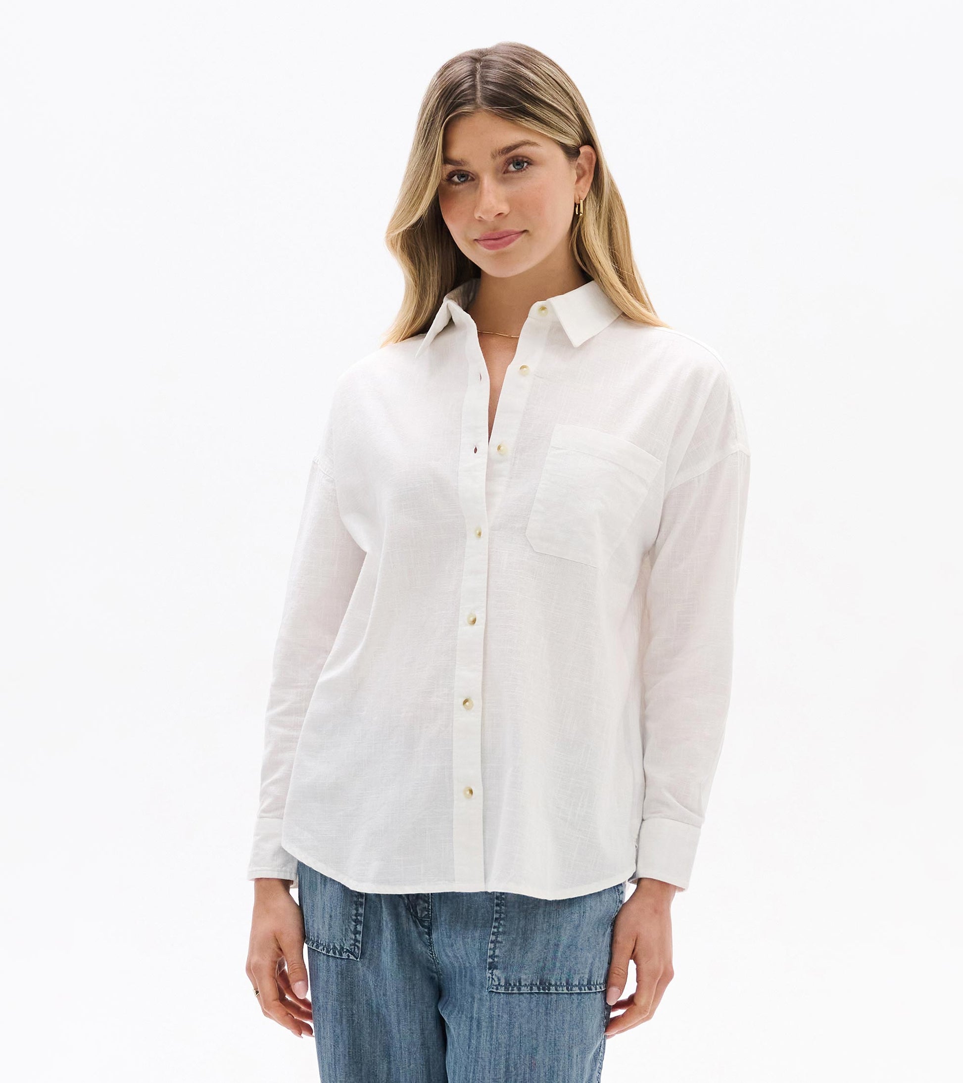 White relaxed button-down shirt on model, front close-up with collar and chest pocket