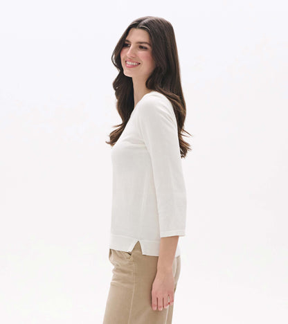 White knit top with 3/4 sleeves, side slit hem, shown on a model in side view.