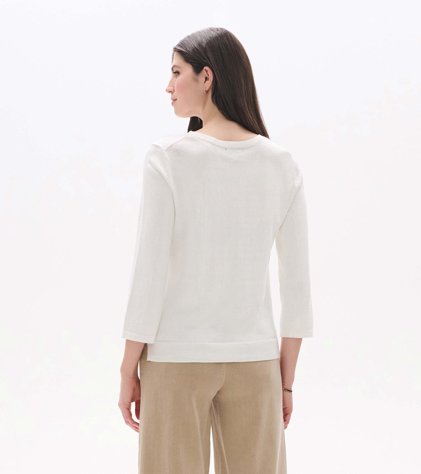 Back view of a white 3/4 sleeve knit top with a crew neck and ribbed hem