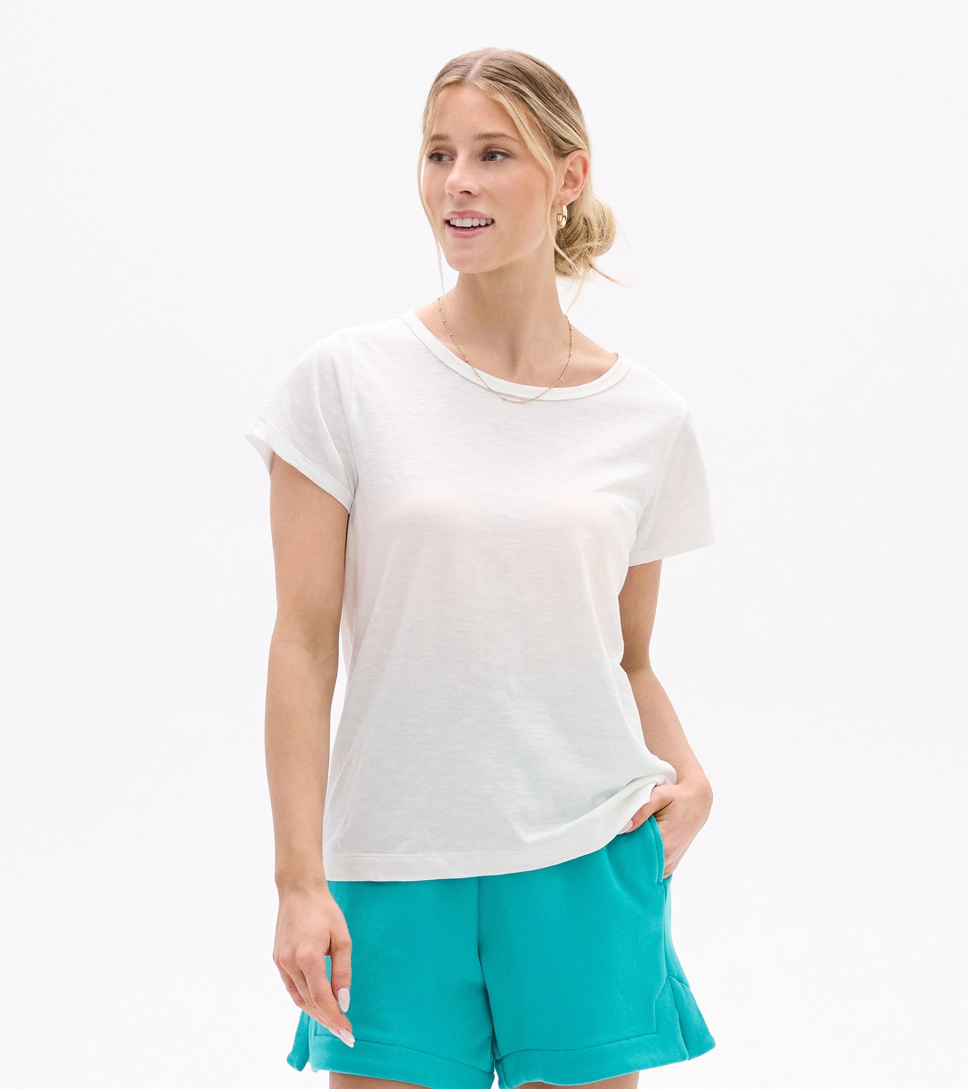 White crew neck short-sleeve tee on a woman, front view, with a relaxed fit and slightly sheer fabric.