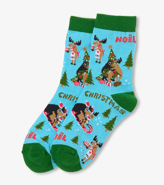 Kids crew socks in light blue with green cuffs, heels and toes, featuring Christmas moose, trees and Noël text