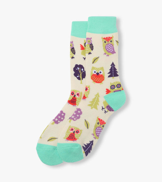 Cream crew socks with turquoise cuffs, heels and toes, featuring colorful owl and tree pattern