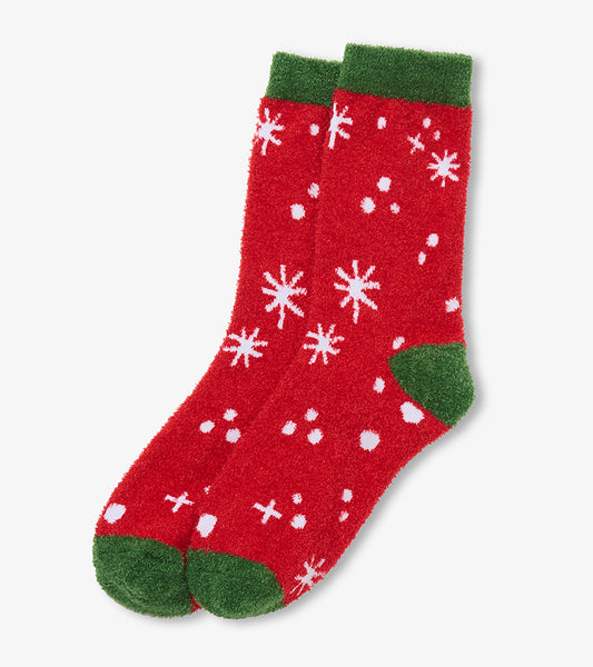 Pair of red fuzzy socks with white snowflakes and dots, plus green cuffs, heels, and toes