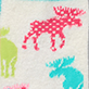 View Women's Patterned Moose Fuzzy Socks - Abstract animal silhouettes in pink, green, and blue on a textured background